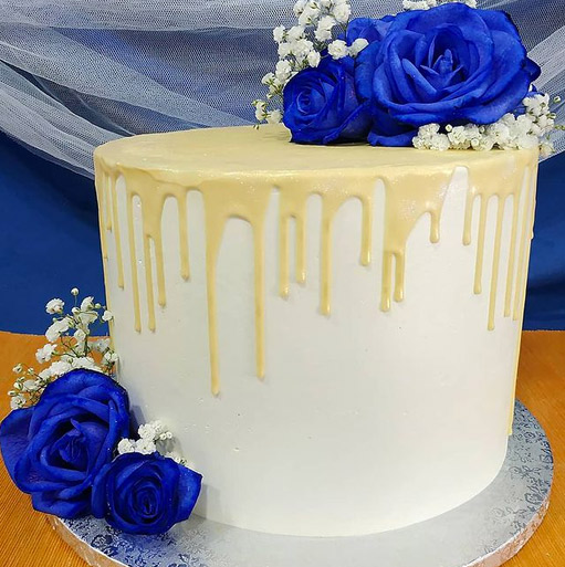 Tarta de boda blanca con goteo de chocolate y rosas azules