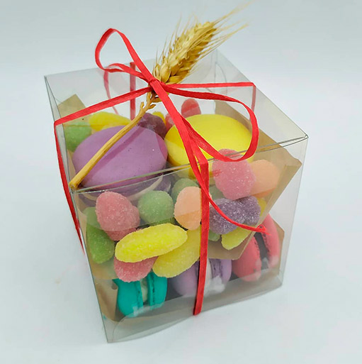 Caja transparente con macarons de colores atada con cintas