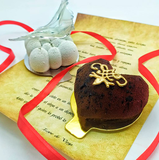 Postre de chocolate en forma de corazón con lazo rojo para San Valentín