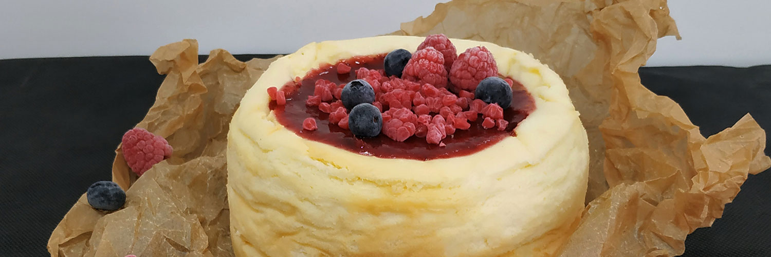 Tarta de queso cubierta de frambuesas y arándanos frescos