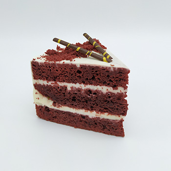 Porción de tarta red velvet con capas de crema de queso