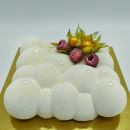 Tarta semifría de mousse blanca con forma de nubes y frutos rojos